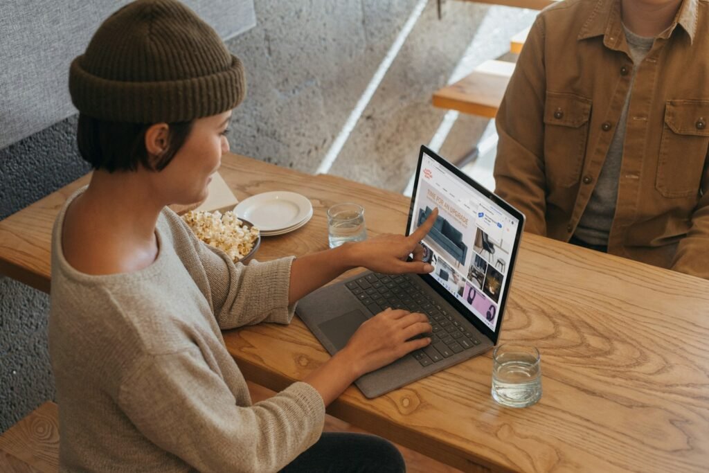 Duas pessoas conversam e revisam informações em um notebook no escritório
